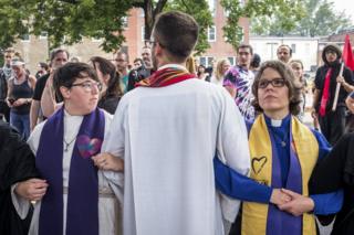 Clergy leaders lock arms at Emancipation park prior to the Unite the Right Rally on August 12, 2017 in Charlottesville