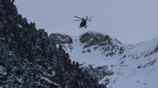 A helicopter flies over the site of an avalanche near Valfrejus, in France