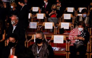 Die wegen sozialer Distanzierung getrennten Zuschauer warten auf den Beginn der ersten Debatte über die Präsidentschaftskampagne 2020