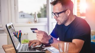 Man at laptop with payment card