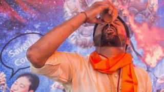 Man drinking cow urine at a "gaumutra" event in Delhi