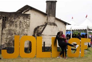 Women hug beside letters reading "Jollof", a popular dish in Nigeria and across West Africa, during the Jollof rice festival in Lagos, on August 20, 2017