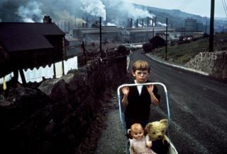 Boy pushing a pram. Wales 1965