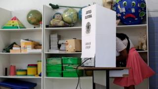 Mulher vota em cabine de votação no primeiro turno das eleições 2018