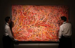 LONDON, ENGLAND - JUNE 04: Sotheby's employees adjust Emily Kame Kngwarreye's 'Wild Yam 2' part of the Aboriginal Art Preview at Sothebys on June 4, 2015 in London, England. The painting forms part of Sotheby's Aboriginal Art Sale which will take place in London on June 10, 2015.