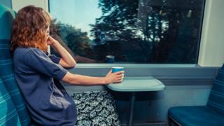 Model posed photo of woman staring out of a train carriage window