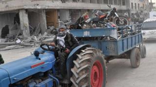 Поддержанный Турцией сирийский бунтарь-повстанец буксирует разграбленные предметы в сирийском городе Африн (18 марта 2018 года)