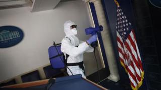 Workers in hazmat suits were seen sanitising eh White House briefing room on Monday