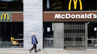 Someone outside a closed McDonald's restaurant