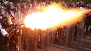 Police officers in Hong Kong fire tear gas at protesters.