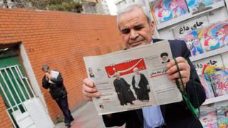 An Iranian man reads a newspaper in Tehran