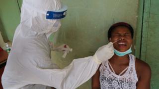 A health worker takes a swab from a woman during a community COVID-19 coronavirus testing campaign in Abuja on April 15, 2020.