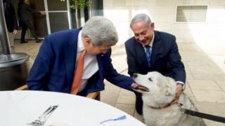 Israeli Prime Minister Benjamin Netanyahu (R) shows U.S. Secretary of State John Kerry his recently adopted dog Kaiya, during their meeting in Jerusalem November 24, 2015