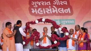 भाजपचे कार्यकर्ते आणि नेते नरेंद्र मोदी आणि अमित शहांना हार घालताना
