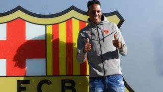 Mina posa frente al escudo del Fútbol Club Barcelona.