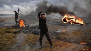 A youth spins a flaming tire as part of a tradition marking the upcoming Clean Monday, the first day of Great Lent in the Eastern Orthodox Christian church calendar, on March 10, 2019 in the Romanian village of Poplaca. - This annual "Clean Monday" ritual, is designed to ward off evil spirits before the onset of Lent on Monday, which marks the beginning of 40 days of abstention, when Orthodox Christians cut out meat, fish, eggs, and dairy