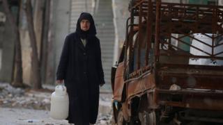 سيدة سورية تبحث عن ماء في حلب القديمة