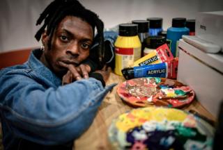 Cameroonian artist Francis Essoua Kalu aka 'Enfant Precoce' poses at his workshop on February 6, 2019 in Paris.