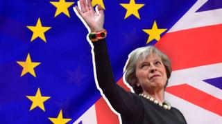 Theresa May against the EU and UK flags