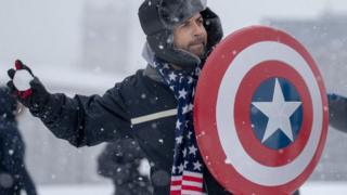 People participate in a snowball fight on the National Mall