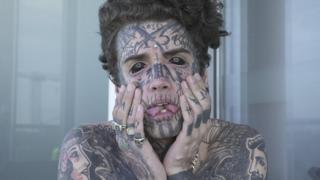 Ethan Bramble hols his heavily-tattooed face and sticks our his forked tongue