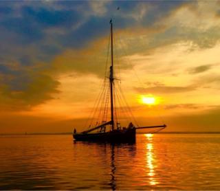 A yacht silhouetted against a sunset