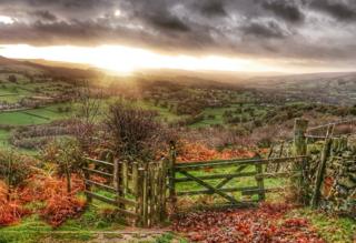 The sun rises over the countryside.