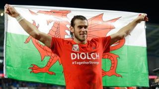 Gareth Bale holding Wales flag