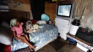 A South African girl and baby watch a live broadcast of the British Royal Wedding of Britain's Prince Harry and Meghan Markle on free national television in a shack in the informal shack settlement of Masiphumelele in Cape Town, South Africa, 19 May 2018