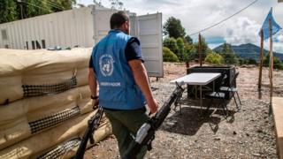 Funcionarios de la ONU con armas entregadas por las FARC