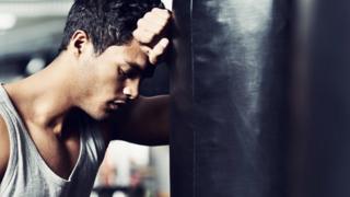 Homem cansado em academia.