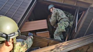 Japanese Self-Defense Force soldiers conduct rescue operations at a collapsed house caused by an earthquake in Wajima