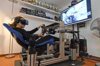 Formula 3 racer Sophia Floersch sits in driving simulator whilst wearing a virtual reality headset