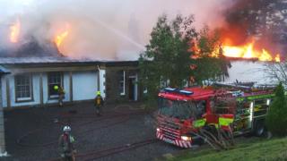 Luchd-smàlaidh a' dèiligeadh leis an teine