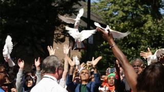 учасники карнавалу відпускають голубів