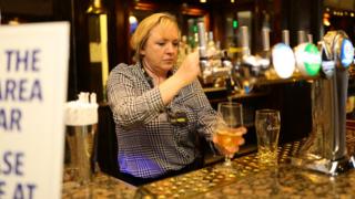 A member of staff pulls the first drink at the reopening The Toll Gate, a Wetherspoons pub in Hornsey, north London