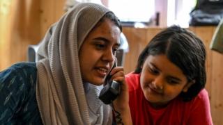 In this photo taken on August 17, 2019, Kashmiri Muslims talk to relatives on a landline phone in Srinagar