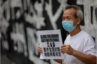 香港醫管局員工陣線成員在醫院管理局大樓外手持標語牌舉行罷工(資料照片)。