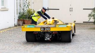 Traffic warden putting parking ticket on Ferrari