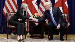 UK Prime Minister Theresa May and US President Donal Trump shaking hands.