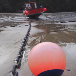 A little fishing boat and buoy at Newquay Harbour in Cornwall