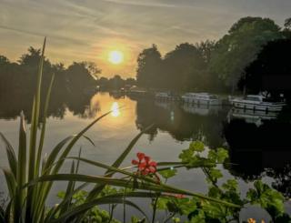 Boats reflected in water at sunrise
