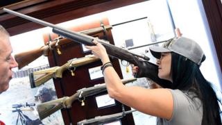 Una mujer prueba un rifle