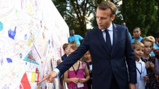 Президент Франции Эммануэль Макрон смотрит на стену с детскими рисунками, поскольку посетителям разрешен доступ к Елисейскому дворцу в Париже 15 сентября 2018 года