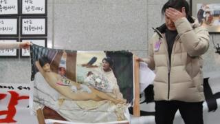 Artist Lee Koo-Young shows his damaged work "dirty sleep", a painting portraying South Korea"s President Park Geun-Hye in the nude, after some conservative protesters damaged the artwork during an exhibition of painting parodies in the lobby of the National Assembly building in Seoul on January 24, 2017.