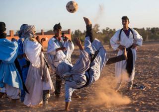 Locals play football during the 15th International Nomad Festival in Mhamid el-Ghizlane in Morocco's southern Sahara desert on March 24, 2018. / AFP PHOTO / FADEL SENNA (Photo credit should read FADEL SENNA/AFP/Getty Images)