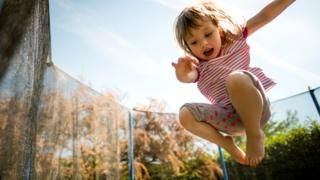 Niña saltando en una colchoneta