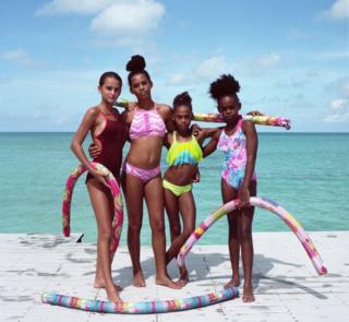 Girls pose next to the sea