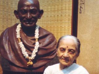 Usha Mehta standing next to a statue of Mahatma Gandhi