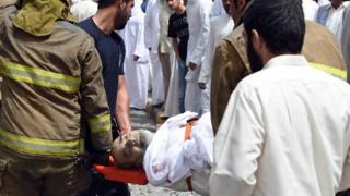A wounded man is stretchered away by emergency services